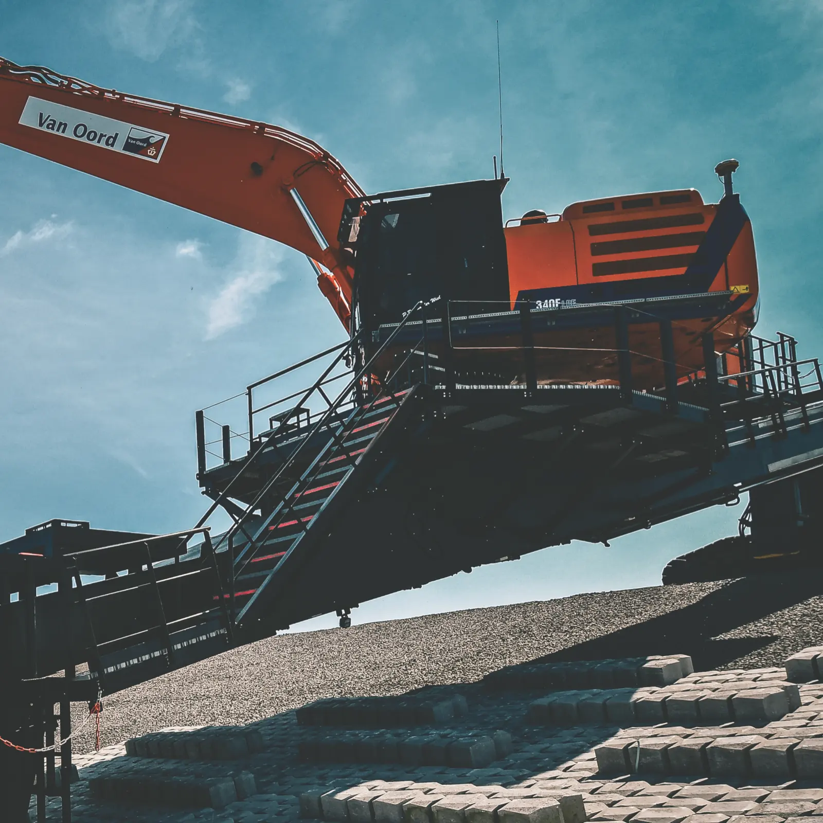Crane placing revetment blocks on the dike.